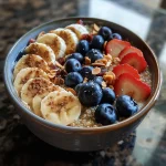 Tigela de café da manhã com quinoa, frutas e sementes.
