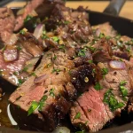 Carne assada na cerveja exibindo suculência e ingredientes frescos ao redor.