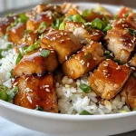 Frango Teriyaki suculento em um prato, exibindo cubos de frango bem caramelizados.