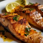 Close-up of perfectly grilled fish fillet garnished with lemon.