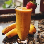 Vitamina de banana e morango em um copo, com aveia visível.