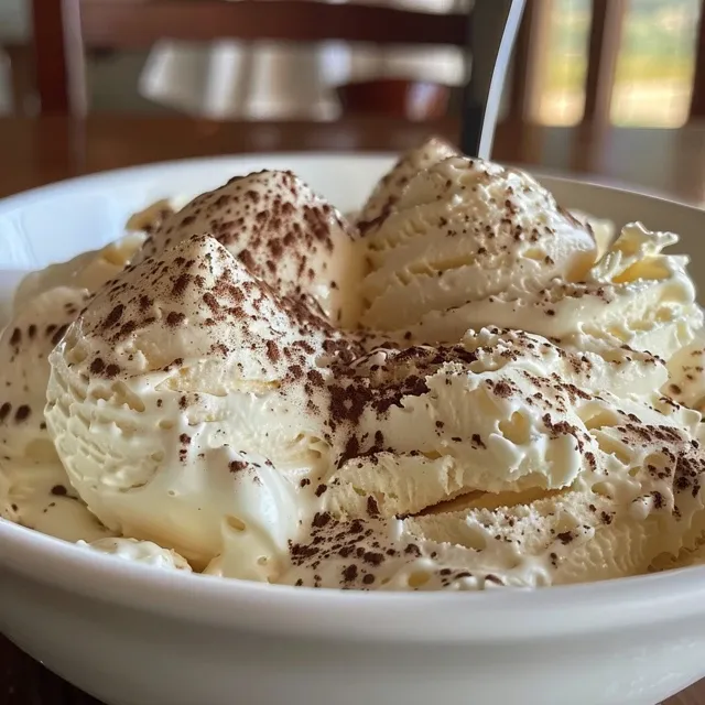 Bolo gelado de chocolate branco com cobertura cremosa, em uma fatia delicada.