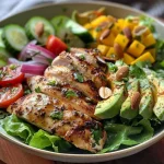 Salada de frango com manga e abacate em um prato, com ingredientes frescos visíveis.