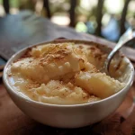 Close-up of a creamy coconuts pudding, showcasing its smooth texture and rich color.
