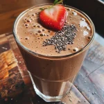 Close-up de um smoothie de banana e chocolate em um copo transparente.