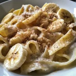 Close-up of a creamy banana and peanut butter smoothie in a glass.