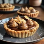 Close-up de tartelettes de chocolate com nozes e fava tonka, mostrando a crosta e o recheio cremoso.