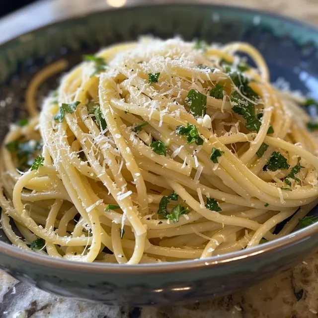 O Sabor do Ver o em Cada Garfada: Aprenda a Fazer Massa de Lim o Refrescante Prato de massa com limão, alho e queijo parmesão, servido em uma tigela branca.