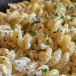 Close-up of a creamy pasta dish with cream cheese and herbs.