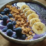 Tigela de smoothie de banana e blueberry em close-up com uma textura cremosa.