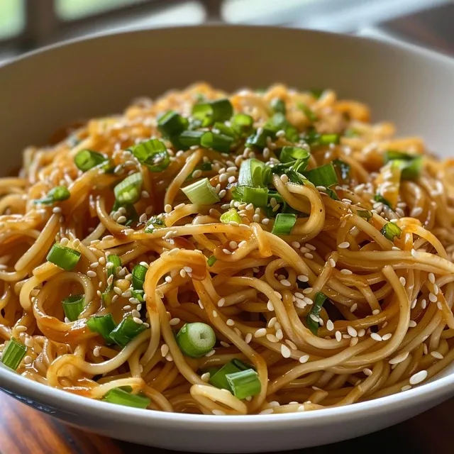 Noodles Gelados com Gergelim: Praticidade e Sabor em Cada Garfada Prato com macarrão frio de gergelim, molho cremoso e sementes de gergelim por cima.