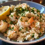 Prato de arroz de limão com camarões, guarnecido com ervas frescas.
