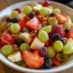 Salada de frutas colorida com morangos, uvas e banana.