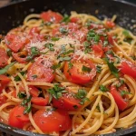 Close-up view of a plate of spaghetti with fresh tomato sauce and basil.