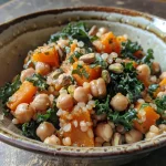 Close-up of a colorful farro grain bowl with butternut squash and chickpeas.