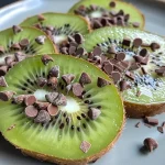 Close-up de um picolé de kiwi coberto com chocolate escuro, com detalhes de gotas de chocolate.