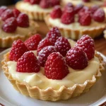Close-up of mini strawberry tartlets filled with custard.