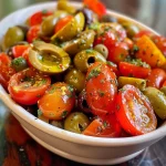 Salada de tomate e azeitona marinada com ingredientes frescos em um prato.