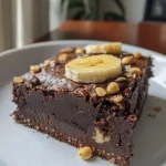 ['Brownie vegano com creme de maracujá em close, com textura cremosa.', 'Fatia de brownie vegano coberta com creme de maracujá, vista lateral.', 'Brownie vegano com cobertura de maracujá, colocando em destaque os ingredientes.', 'Close de um brownie vegano decorado com creme de maracujá, visual apetitoso.']