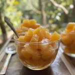 ['Copo de chá gelado de maracujá com hortelã fresca.', 'Chá gelado de maracujá em um copo com cubos de gelo.', 'Close de chá gelado de maracujá com fatias de maracujá ao lado.', 'Bebida refrescante de chá gelado de maracujá em um ambiente ensolarado.']