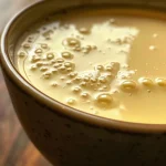 ['Creme de milho cremoso, servido em um recipiente.', 'Close-up de um prato de creme de milho decorado.', 'Porção de creme de milho com textura suave e sedosa.', 'Creme de milho em uma tigela, exibindo ingredientes frescos.']