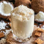 ['Close-up de um pavê de coco com biscoitos Tostines.', 'Pavê de coco cremoso em uma taça, com biscoitos Tostines.', 'Camadas de pavê de coco decorado com coco ralado.', 'Vista lateral de um pavê de coco com biscoitos e coco.']