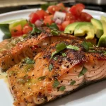 ['Filé de salmão grelhado com salsa de abacate fresca.', 'Prato saudável de salmão grelhado com guarnição de abacate.', 'Close de salmão grelhado coberto por salsa de abacate.', 'Salmão grelhado servido com salsa colorida de abacate.']