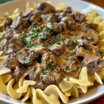 ['Prato de Stroganoff de Carne com molho cremoso.', 'Close de um Stroganoff de Carne rico em proteínas.', 'Prato saboroso de Stroganoff de Carne servido com macarrão.', 'Carne moída em molho cremoso com cogumelos e macarrão.']