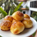 ['Bolinho de chuva FIT dourado e apetitoso em close.', 'Um bolinho de chuva saudável, com textura macia e polvilhado com canela.', 'Delicioso bolinho de chuva FIT, visto de lado, mostrando sua textura suculenta.', 'Close de um bolinho de chuva FIT, destacando sua cor e aspecto caseiro.']