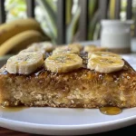 ['Bolo fit de banana com aveia em fatias, mostrando a textura macia.', 'Close de um bolo fit de banana, com aveia, em uma mesa rústica.', 'Bolo saudável de banana e aveia, com pedaços de fruta visíveis.', 'Bolo fit de banana com aveia, lado a lado com ingredientes frescos.']