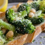 ['Prato de brócolis com feijão branco e molho.', 'Close de brócolis frescos e feijão branco em uma salada.', 'Salada de brócolis e feijão branco com pedaços de pão tostado.', 'Prato de brócolis grelhados com feijão branco e parmesão.']