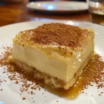 ['Creme de milho cremoso em um recipiente.', 'Close de um prato de creme de milho.', 'Tigela de creme de milho com consistência aveludada.', 'Creme de milho servido com cebola e alho.']