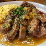 ['Close-up de um escondidinho de mandioca com carne moída, com camadas bem definidas.', 'Prato de escondidinho de mandioca com carne moída, mostrando a textura cremosa do purê.', 'Porção de escondidinho de mandioca e carne moída, com queijo gratinado por cima.', 'Vista lateral de escondidinho de mandioca com carne moída, evidenciando os ingredientes.']