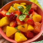 ['Close-up de uma bebida refrescante com morangos e folhas de manjericão.', 'Infusão fria de morango e manjericão em um copo com gelo.', 'Detalhe de uma infusão com morangos frescos e folhas verdes de manjericão.', 'Bebida gelada de morango e manjericão em uma apresentação vibrante.']