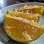 ['Limão com casca e alho em uma mesa.', 'Close up de limões e dentes de alho.', 'Limões frescos com casca ao lado de alho.', 'Ingredientes de receita: limão e alho em destaque.']