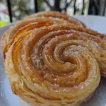 ['Palmier crocante e dourado em close.', 'Detalhe de um Palmier recém-assado.', 'Palmier com textura folhada e açúcar cristal.', 'Vista lateral de um Palmier apetitoso.']