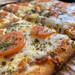 ['Pizza de frigideira com queijo derretido e ingredientes frescos.', 'Close-up de uma pizza de frigideira suculenta em um prato.', 'Fatia de pizza de frigideira com cobertura de queijo e vegetais.', 'Pizza de frigideira dourada com recheios variados.']