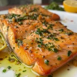 ['Filé de salmão grelhado com molho de ervas e limão.', 'Salmão grelhado servido com molho de ervas frescas e limão.', 'Prato de salmão grelhado com molho aromático de limão.', 'Close-up de salmão grelhado com ervas e limão.']