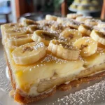 ['Torta de banana cremosa com camadas visíveis de banana.', 'Close-up de uma fatia de torta de banana cremosa, destacando a textura.', 'Vista lateral de uma torta de banana cremosa, mostrando sua riqueza.', 'Fatia de torta de banana cremosa com recheio sedoso e bananas.']