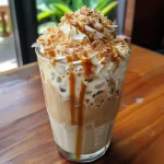Café gelado com caramelo e coco em um copo transparente.
