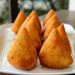 Coxinha de morango com cobertura de leite em pó.