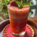 Copo de ponche com frutas vermelhas, vodka e champanhe.