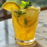 Refresco de cítricos com gengibre em um copo transparente.