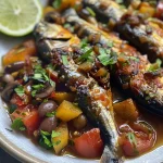 Sardinha assada com legumes variados em uma travessa.
