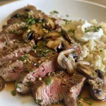Prato de strogonofe de carne com arroz, apresentado de lado.