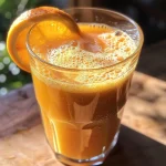 Copo de suco detox de beterraba com laranja em destaque.