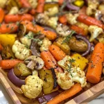 Vegetais assados com maple e mostarda, incluindo cenouras, couve-flor e cogumelos.
